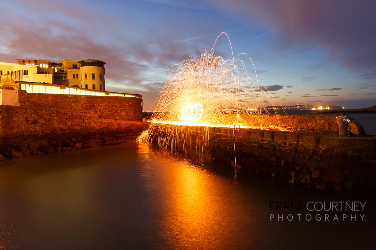 Coliemore Harbour long exposure with steel wool spinning. Howth Head in the background.